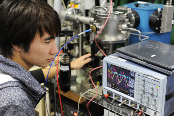 Photo of a young man looking at an oscilloscope.
